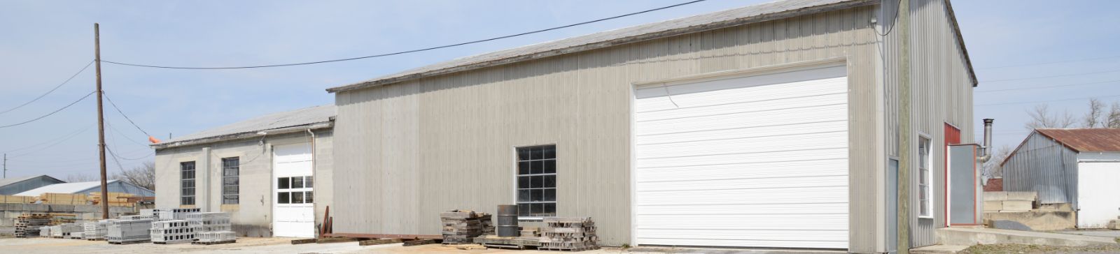 Industrial building with large white garage doors and concrete blocks outside in Saratoga Springs